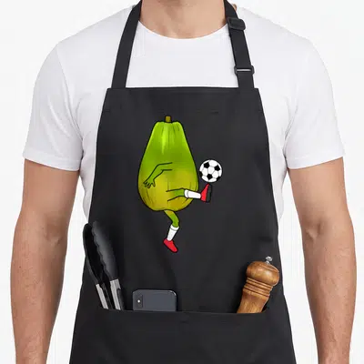 Tablier de cuisine noir avec une illustration d'une papaye aux pieds jouant au ballon de foot.