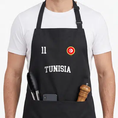 Tablier de cuisine noir avec le numéro 11, le mot TUNISIA et le logo circulaire du drapeau tunisien en rouge et blanc.