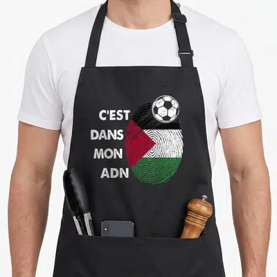 Tablier de cuisine noir avec empreinte digitale aux couleurs du drapeau Palestine et ballon de foot blanc en haut à droite.