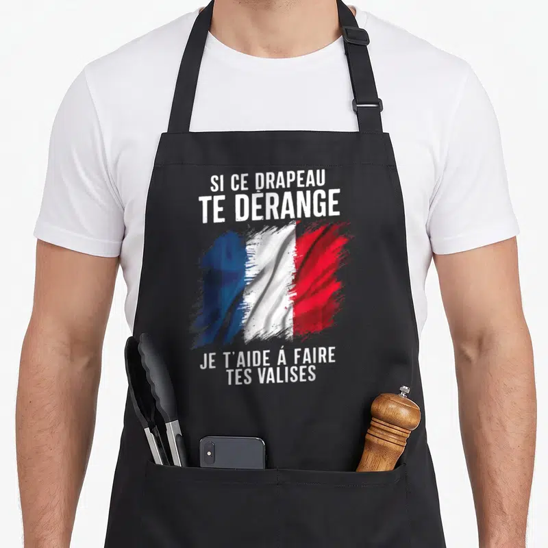 Tablier de cuisine noir avec illustration du drapeau français aux couleurs vives et texte blanc provocateur imprimé au centre.