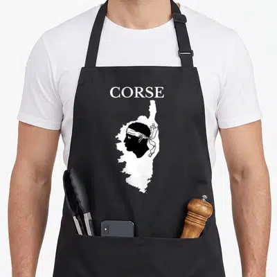 Tablier de cuisine noir avec une carte blanche de la Corse contenant un profil corse coiffé d'un bandana blanc.