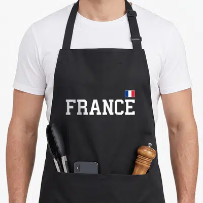 Tablier de cuisine noir avec linscription FRANCE en blanc et un petit drapeau tricolore en haut à droite.