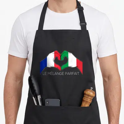 Tablier de cuisine noir avec deux mains formant un cœur aux couleurs des drapeaux français et italien, le mélange parfait