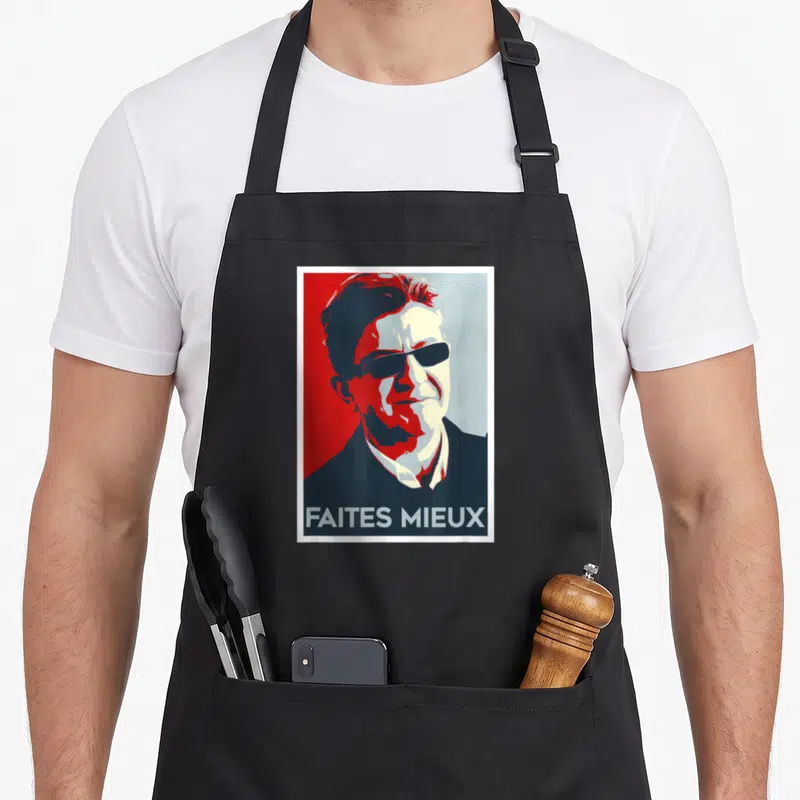 Tablier de cuisine noir avec un portrait graphique rouge et bleu portant l'inscription faites mieux en bas du motif imprimé.