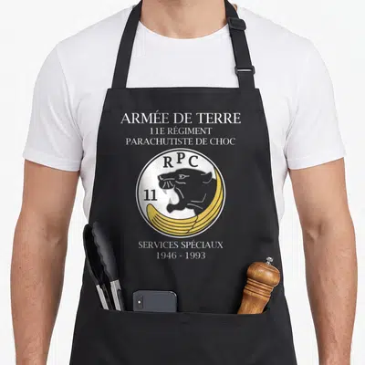 Tablier de cuisine noir avec le logo circulaire du 11e Régiment Parachutiste de Choc et un léopard stylisé.