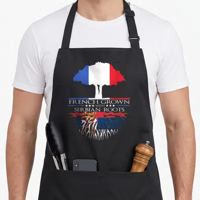 Tablier de cuisine noir avec un arbre tricolore et des racines arborant le blason serbe.