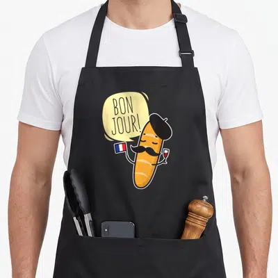 Tablier de cuisine noir avec une baguette animée portant béret, moustache, drapeau et verre de vin.