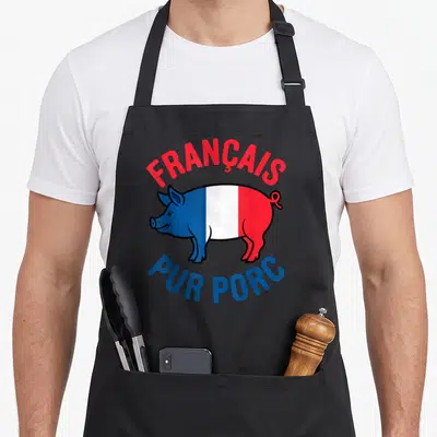 Tablier de cuisine noir avec illustration d'un porc tricolore et les mots français pur porc en lettres colorées.