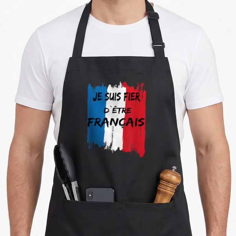 Tablier de cuisine noir avec un drapeau français stylisé et l'inscription Je suis fier d'être français en lettres noires.