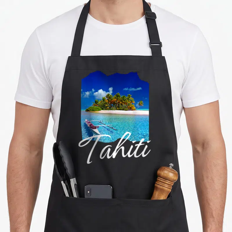 Tablier de cuisine noir avec une illustration colorée d'une île tropicale et le mot Tahiti en lettres blanches élégantes.