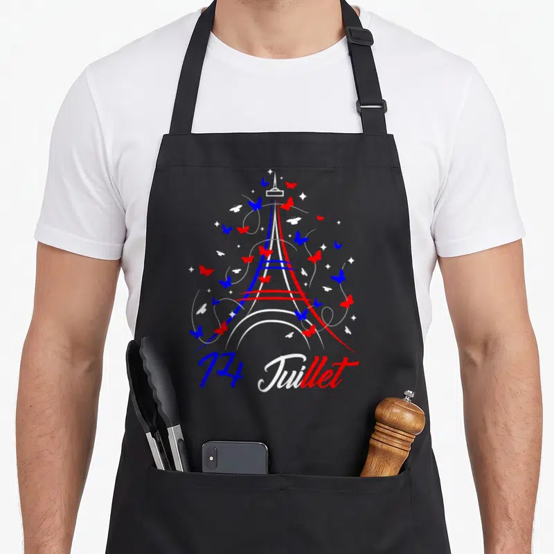 Tablier de cuisine noir avec une tour Eiffel stylisée aux couleurs tricolores entourée de papillons et de l'inscription 14 Juillet.