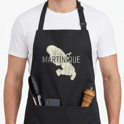 Tablier de cuisine noir avec une carte Martinique en texte blanc texturé formant la silhouette de l'île.