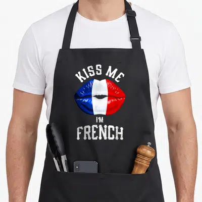 Tablier de cuisine noir orné de lèvres aux couleurs du drapeau français et texte blanc stylisé.