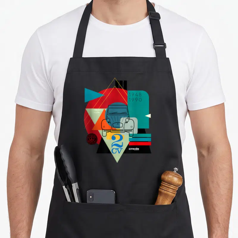 Tablier de cuisine noir avec une illustration géométrique colorée représentant l'avant d'une Citroën 2CV et les dates 1948 1990.