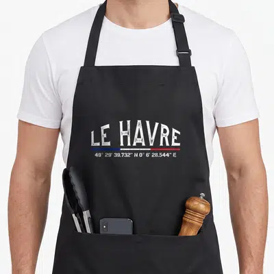 Tablier de cuisine noir avec inscription Le Havre et coordonnées géographiques en blanc sur fond uni.