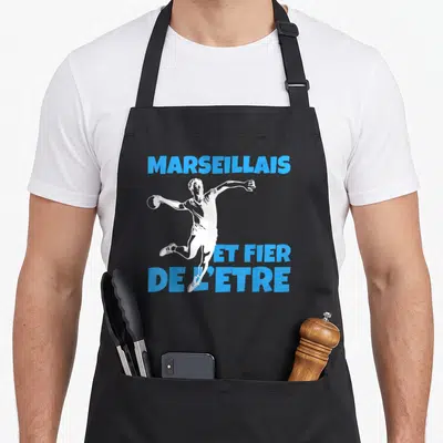 Tablier de cuisine noir avec illustration d'un sportif blanc et texte bleu Marseillais et fier de l'être.