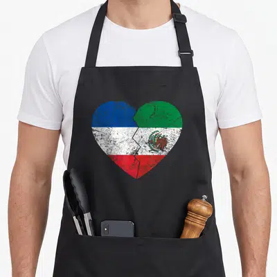 Tablier de cuisine noir avec un grand cœur affichant les couleurs du drapeau français et l'aigle du drapeau mexicain en style vintage.