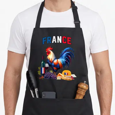 Tablier de cuisine noir avec un coq gaulois, du vin, des fromages et le mot France en lettres tricolores.