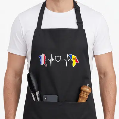 Tablier de cuisine noir avec carte France Moldavie et ligne cardiaque blanche reliant les deux drapeaux nationaux.