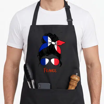 Tablier de cuisine noir avec une femme aux verres et chignon aux couleurs du drapeau français.