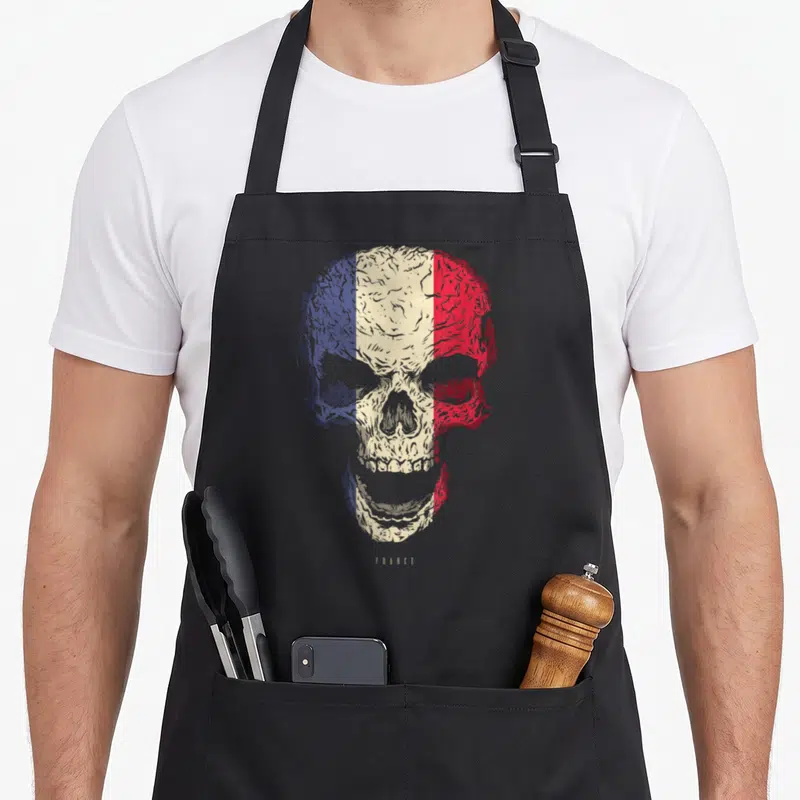 Tablier de cuisine noir avec un crâne aux couleurs du drapeau français et l'inscription France en bas.