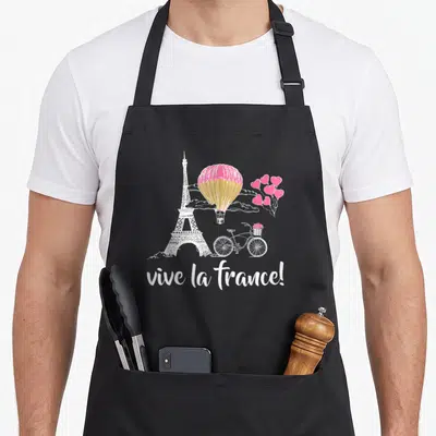 Tablier de cuisine noir avec illustration blanche de la Tour Eiffel, ballon rose et vélo romantique.