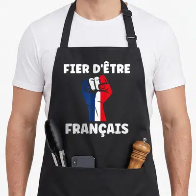 Tablier de cuisine noir avec un poing tricolore et l'inscription fier d'être français en lettres blanches.