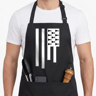 Tablier de cuisine noir avec le drapeau Breizh blanc et noir comportant des ermines stylisées en grille régulière.