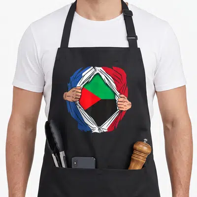 Tablier de cuisine noir avec illustration mains déchirant vêtement revealing drapeaux France et Martinique.