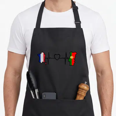 Tablier de cuisine noir avec carte France et Portugal reliées par un rythme cardiaque et un cœur central.