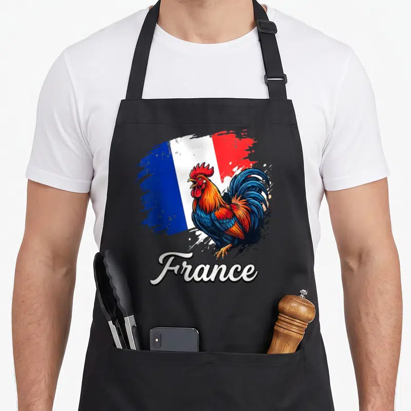 Tablier de cuisine noir avec un coq gaulois multicolore sur fond de drapeau français peint à la brosse et le mot France en bas.