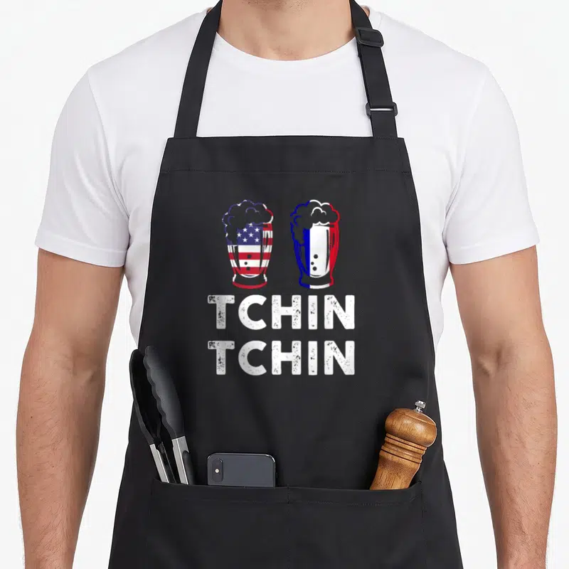 Tablier de cuisine noir avec deux verres de bière aux drapeaux américain et français et le texte Tchin Tchin en blanc.