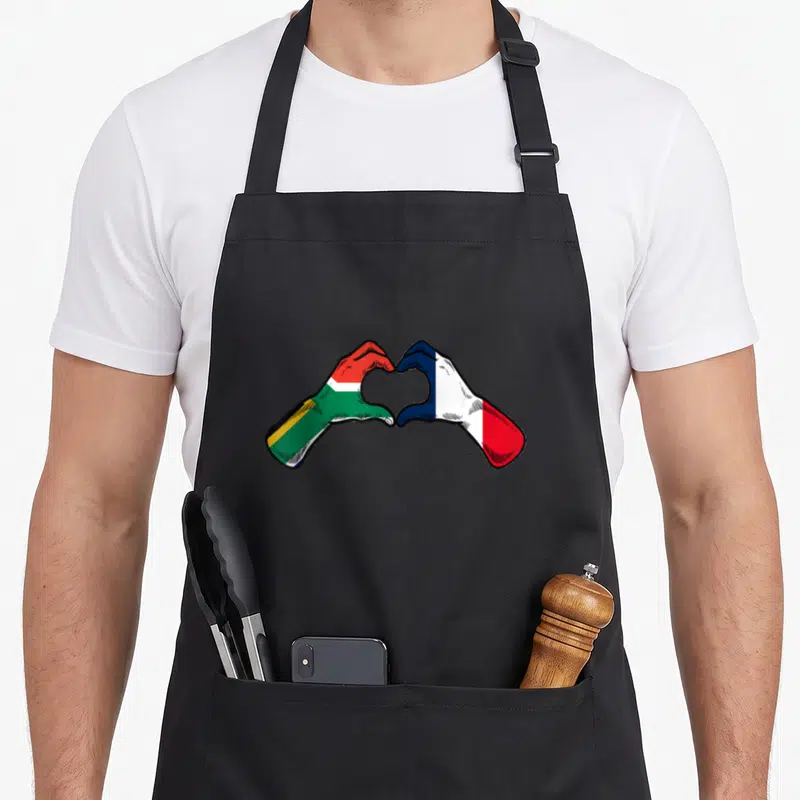 Tablier de cuisine noir avec deux mains formant un cœur, l'une au drapeau Afrique du Sud, l'autre au drapeau France.