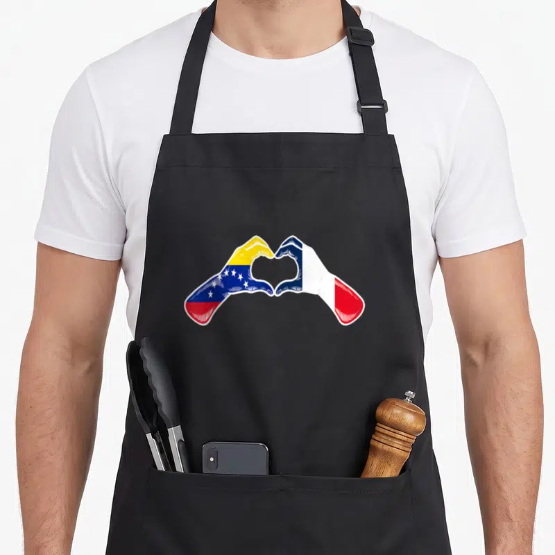 Tablier de cuisine noir avec deux mains formant un cœur aux couleurs des drapeaux Venezuela et France.