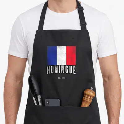 Tablier de cuisine noir avec drapeau français texturé et inscription HUNINGUE FRANCE en blanc.