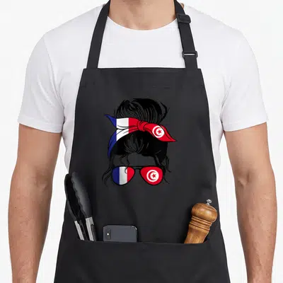 Tablier de cuisine noir avec illustration femme chignon bandano et lunettes soleil aux drapeaux français et tunisien.