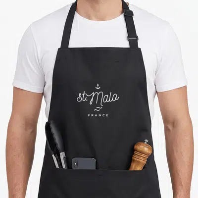 Tablier de cuisine noir avec inscription st Malo France, ancre et motifs de vagues en typographie blanche.