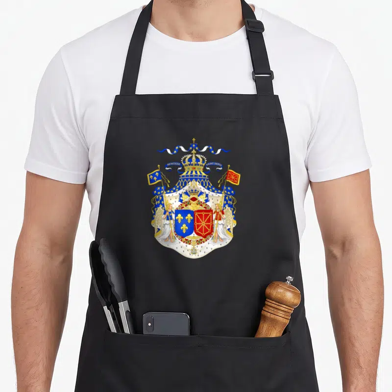 Tablier de cuisine noir avec un grand blason royal bleu rouge or et deux anges soutenant l'écu sous une couronne.