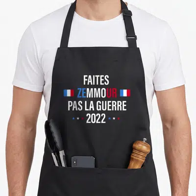 Tablier de cuisine noir avec l'inscription Faites Zemmour pas la guerre 2022 encadrée par des drapeaux français.