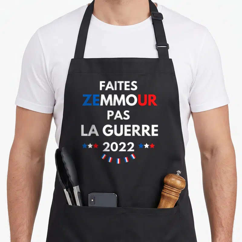 Tablier de cuisine noir avec l'inscription Faites Zemmour pas la guerre 2022 et des guirlandes tricolores.