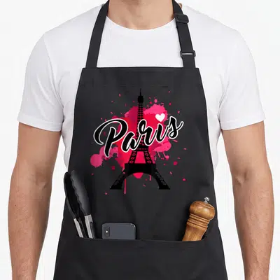 Tablier de cuisine noir avec le mot Paris en écriture cursive, une Tour Eiffel noire et des éclaboussures roses vives.