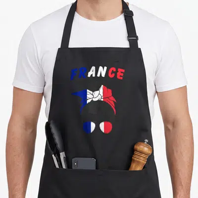 Tablier de cuisine noir avec une illustration de femme au bandeau et lunettes aux couleurs du drapeau français et l'inscription FRANCE.