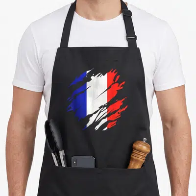 Tablier de cuisine noir avec un drapeau français stylisé en coups de pinceau bleu blanc rouge.