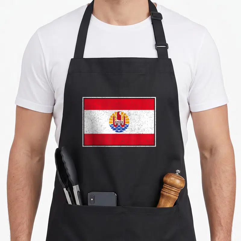 Tablier de cuisine noir avec le drapeau de Polynésie française et l'emblème central XXXXX imprimé en couleur.