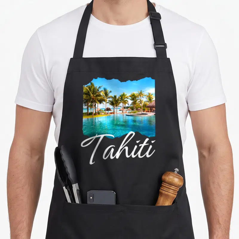 Tablier de cuisine noir avec une illustration de plage tahitienne et le mot Tahiti en lettres blanches cursives.