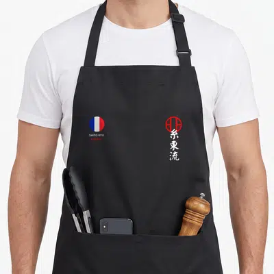 Tablier de cuisine noir avec logo drapeau français et caractères japonais Shito Ryu en rouge et blanc.