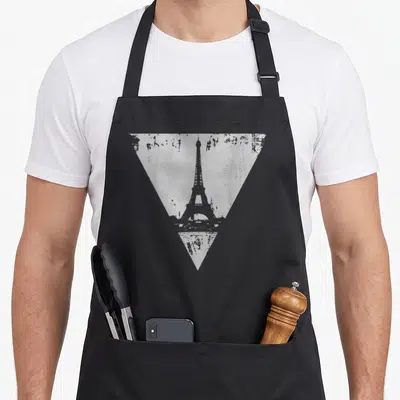 Tablier de cuisine noir avec une illustration triangulaire grise représentant la Tour Eiffel dans un style vieilli et délavé.