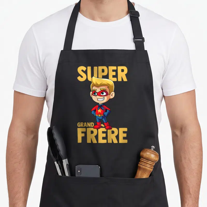 Tablier de cuisine noir avec illustration super héros grand frère masque rouge et texte jaune.