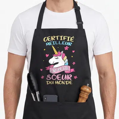 Tablier de cuisine noir avec illustration de licorne rose et texte certifié meilleur grande sœur du monde.