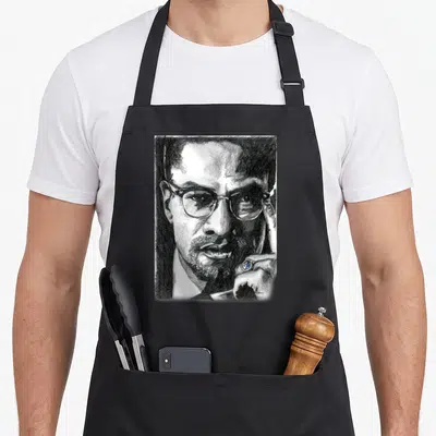 Tablier de cuisine noir avec portrait au crayon de Frère Malcolm portant des lunettes et un anneau à l'index.